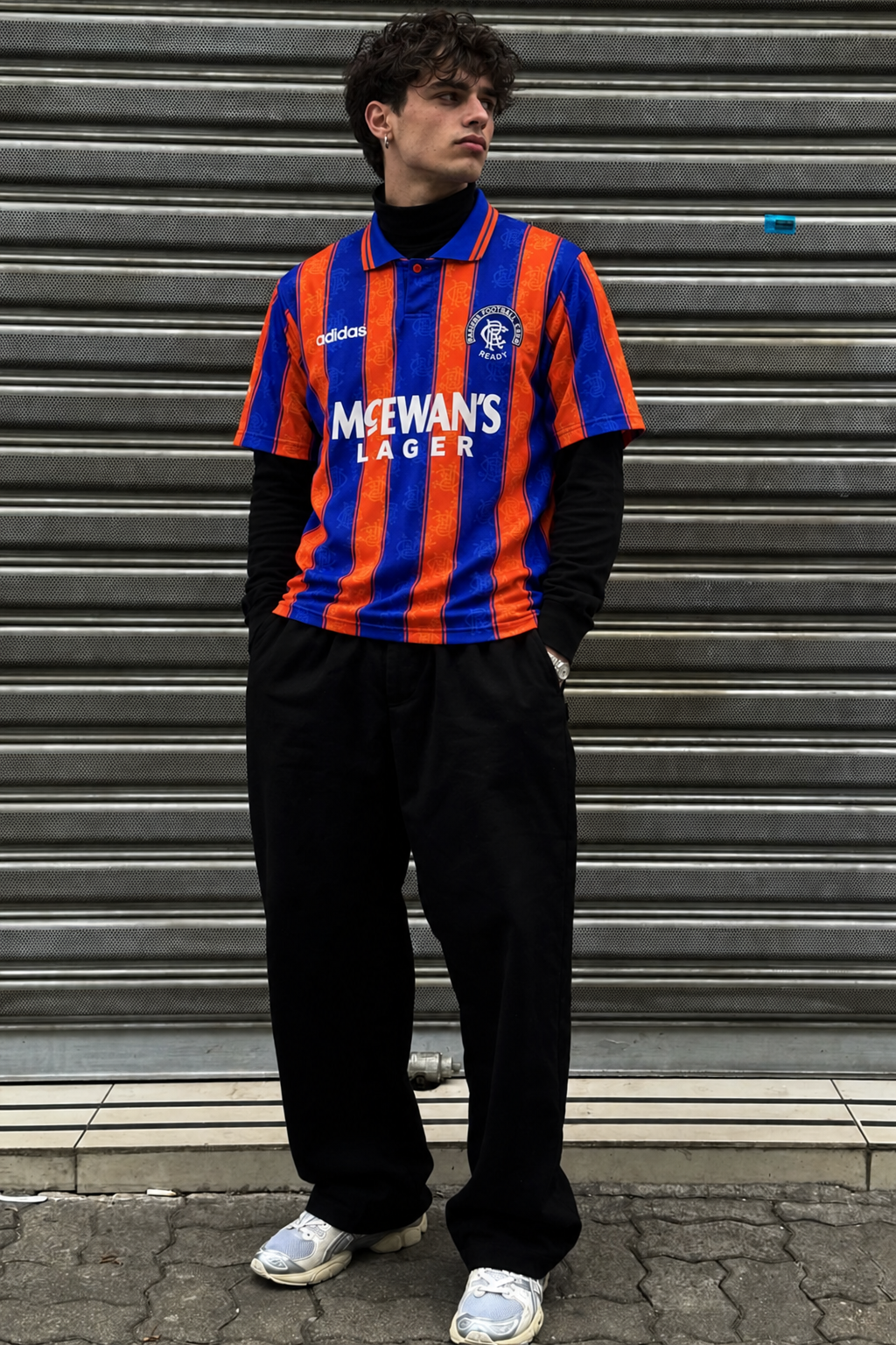 Model wearing Rangers 1993-94 blue and orange McEwan's Lager away shirt in gritty streetwear styling